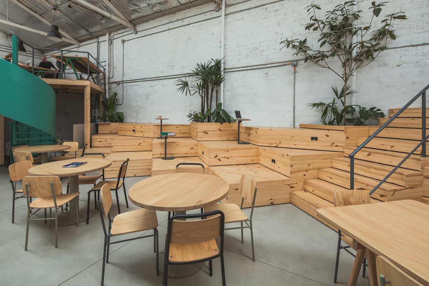 Área de café e refeições sob os mezaninos de madeira