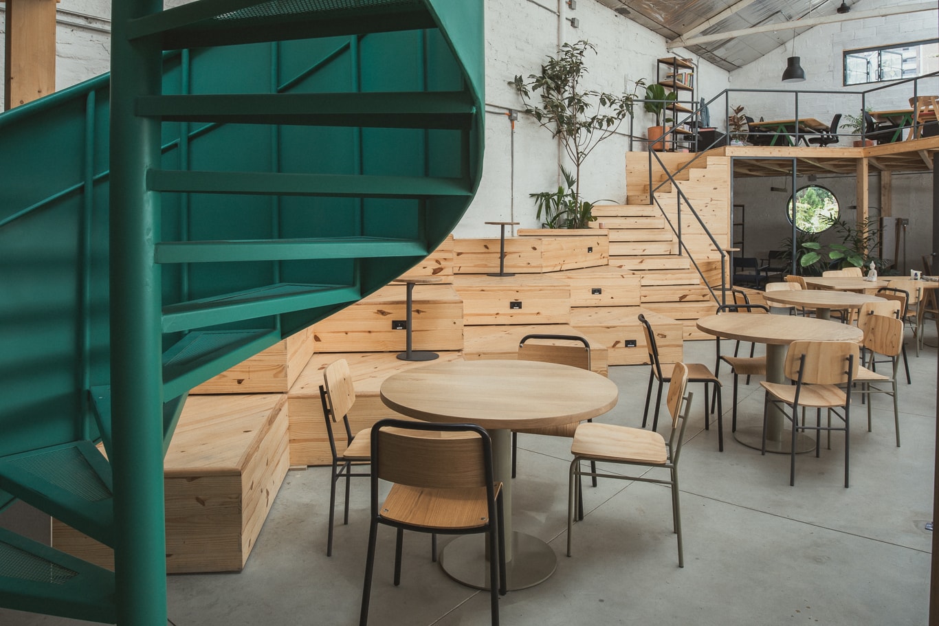 Ambiente de trabalho coletivo com mesas compartilhadas e iluminação zenital